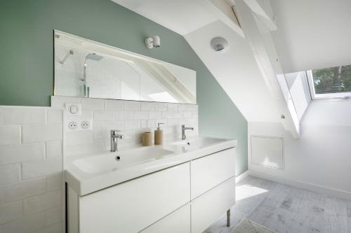 une salle de bain blanche avec un lavabo et une fenêtre dans l'établissement Superbe maison pour 8 - 500m de la plage - Jardin, à Pornichet