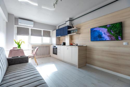a living room with a kitchen and a tv on a wall at Rezidential Park Letea by Rooms in Bacău