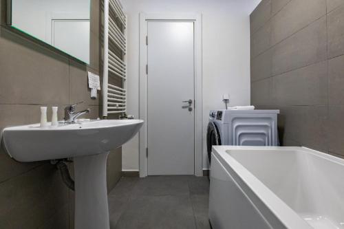 a bathroom with a sink and a bath tub at Rezidential Park Letea by Rooms in Bacău