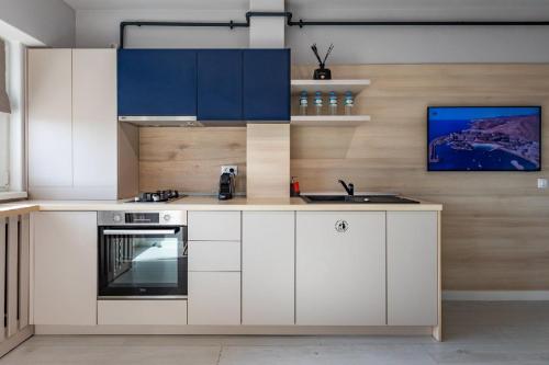 a kitchen with white cabinets and a sink at Rezidential Park Letea by Rooms in Bacău