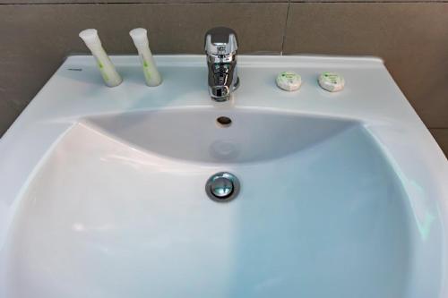 a white bathroom sink with two toothbrushes on it at Rezidential Park Letea by Rooms in Bacău