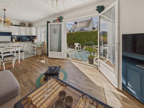 d'un salon avec une grande porte coulissante en verre menant à une terrasse. dans l'établissement Maison pour 4 avec grand jardin - Pont Aven, à Pont-Aven