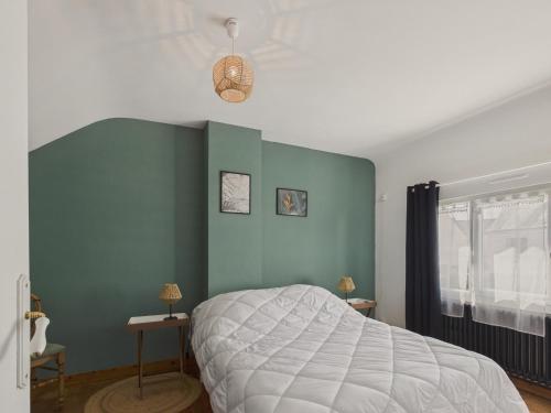 a bedroom with a bed and a green wall at Maison pour 4 avec grand jardin - Pont Aven in Pont-Aven