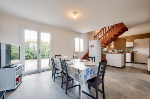 une cuisine et une salle à manger avec une table et des chaises dans l'établissement Maison pour 6 avec terrasse et jardin, à Guissény