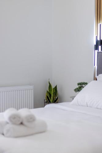 a white bed with two white towels on it at G&J Minimal House in Tríkala