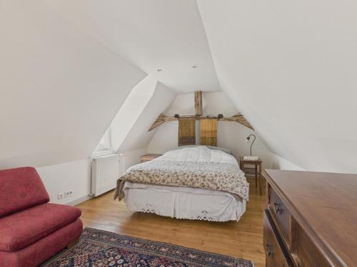 a bedroom with a bed and a red couch at Charmante maison dans le Perigord Noir pour 7 in Plazac