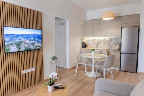 a living room with a table and a kitchen at G&J Minimal House in Tríkala