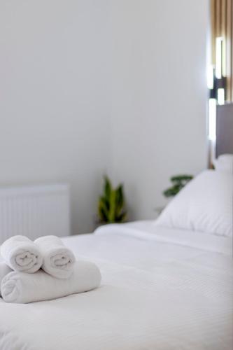 two towels sitting on top of a white bed at G&J Minimal House in Tríkala