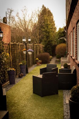 a garden with chairs on the grass next to a building at Hotel Ammerland garni in Wilhelmshaven