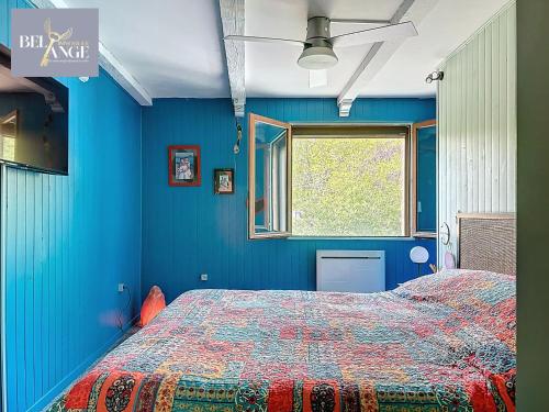 une chambre bleue avec un lit et une fenêtre dans l'établissement Maison spacieuse et climatisée avec jacuzzi, à Molières-sur-Cèze