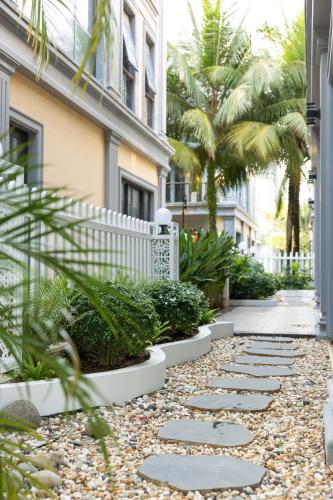 a walkway in front of a building with palm trees at Family Villa - Phu Quoc Island in Phu Quoc