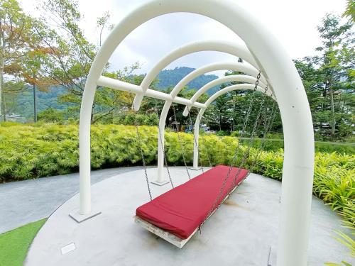 a swing with a red seat in a white canopy at Windmill Upon Hills Genting Highland in Genting Highlands