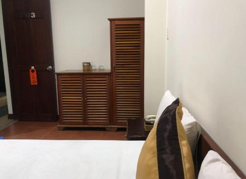 a bedroom with a bed and a wooden cabinet at Khách sạn Sơn Hải in Ho Chi Minh City