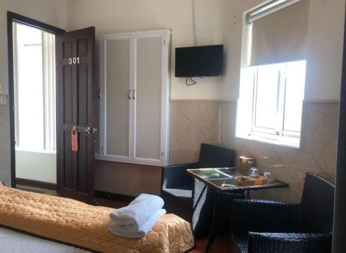 a hotel room with a bed and a table and window at Khách sạn Sơn Hải in Ho Chi Minh City