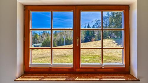 斯克拉斯卡波伦巴Apartamenty Lola SPA - najbliżej wyciągu - by Royal Aparts的一扇敞开的窗户，可以看到田野