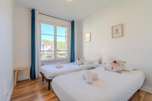 deux lits dans une chambre avec une fenêtre dans l'établissement Nova apartment Disneyland Bmyguest, à Serris