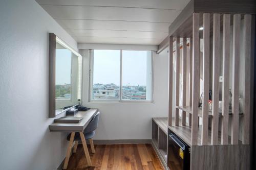 a bathroom with a desk and a mirror and a window at Thong Tarin Hotel in Surin