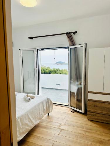 a bedroom with a bed and a large glass door at Katsadia Beach 1 Bedroom in Vrachonisída Líra
