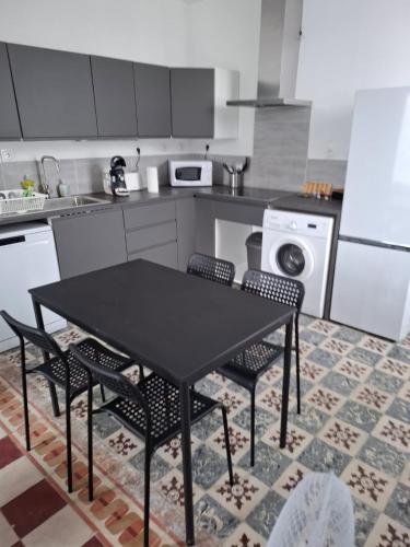 une cuisine avec une table et des chaises noires dans l'établissement Le T2 Wilson, à Carcassonne