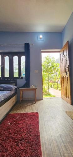 a bedroom with a bed and a door with a red rug at Batuwa Resort in Kusma