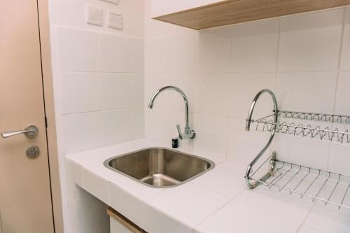 a kitchen sink with two faucets on a counter at Nice and Comfort Studio Apartment at Tokyo Riverside PIK 2 By Travelio in Rawalembang