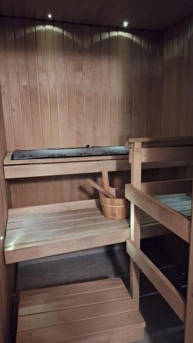 eine Sauna mit zwei Holzregalen und einem Korb in der Unterkunft Saunallinen rivitalohuoneisto in Joensuu