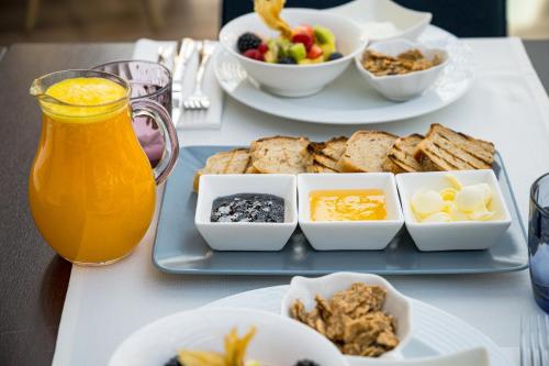 a table with a tray of breakfast foods and a pitcher of orange juice at Villa Prato in Braşov