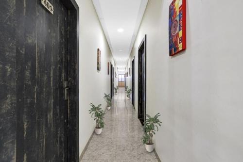 a hallway with two potted plants in a building at Hotel Pearl Villa in Ahmedabad