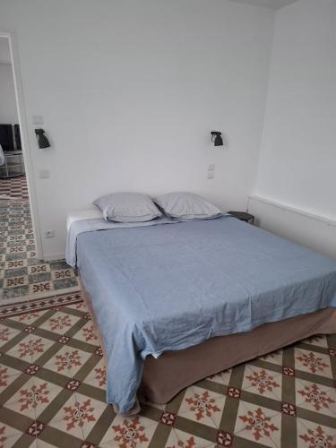 une chambre avec un lit avec une couverture bleue dans l'établissement Le T2 Wilson, à Carcassonne