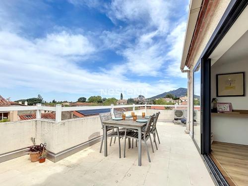 a table and chairs on a balcony with a view at 3721-Duplex dans les Albères in Laroque-des-Albères