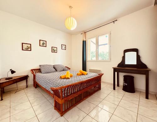 a bedroom with a bed and a table and a mirror at Maison avec piscine-climatisation-jardin in Ventenac en Minervois