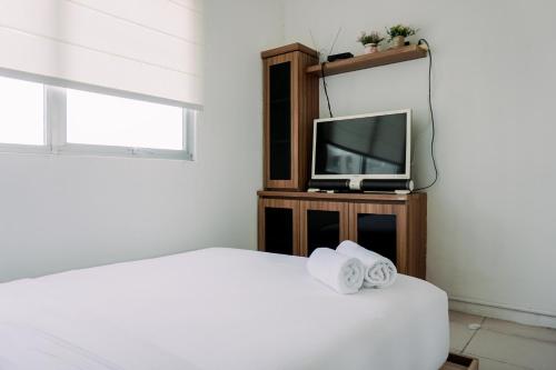 - une chambre avec un lit et une télévision dans l'établissement Homey and Comfort Stay 2BR Pakubuwono Terrace Apartment By Travelio, à Jakarta