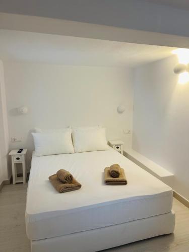 a bedroom with a white bed with two hats on it at 2-bedroom LOFT apartment in Megali Ammos