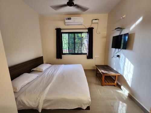 a bedroom with a white bed and a window at Sai Sharad Guest House in Naozor
