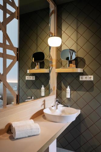 a bathroom with a sink and a mirror at ARCOTEL AQ Wien in Vienna