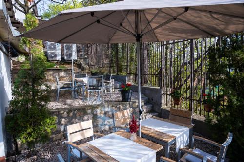 a patio with two tables and an umbrella at Villa Prato in Braşov