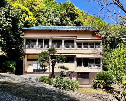 a large house with a balcony and trees at Retreat wabi-sabi - walk to Ohama Beach - Max 12 ppl in Shimoda