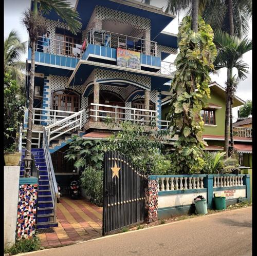 a blue building with stairs and a gate at Marcelo Palace - Baga in Calangute