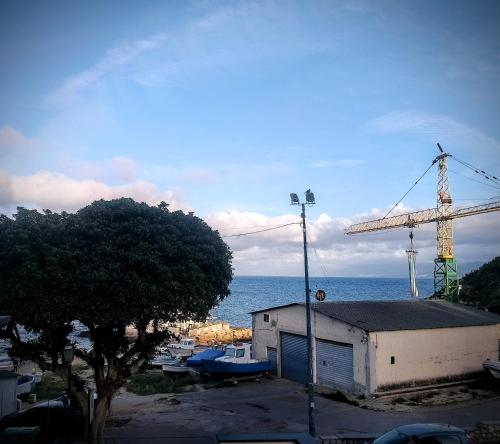 a crane and a building next to the water at Guest House Lo specchio sul mare in Santa Flavia