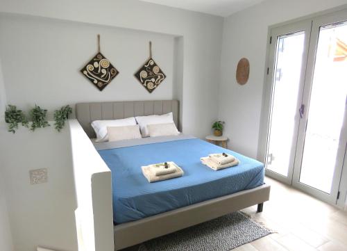 a bedroom with a bed with two towels on it at Astra Viollonette- cozy with sea view and shared pool near the beach -BY APOKORONAS VILLAS in Kókkinon Khoríon