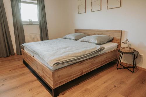 a bedroom with a large bed with a wooden frame at Ferienwohnung - LIVING Six in Eging