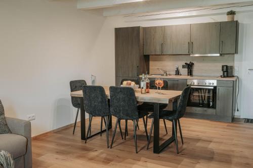 a kitchen with a table and chairs in a room at Ferienwohnung - LIVING Six in Eging