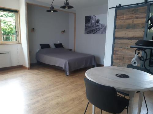 - une chambre avec un lit, une table, un lit, une table et des chaises dans l'établissement Le Petit Gîte de la gare, à Saint-Pompain