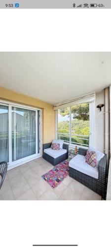 une véranda avec deux canapés et une table dans l'établissement Super 3 pièces cannes, à Cannes