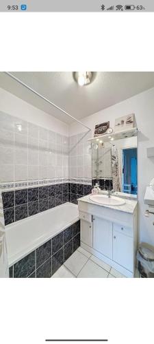 une salle de bain avec une baignoire, un lavabo et un miroir dans l'établissement Super 3 pièces cannes, à Cannes