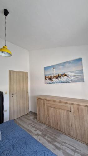 a bedroom with a bed and a painting of a lighthouse at Apartman Magdalena in Kastel Stafilic