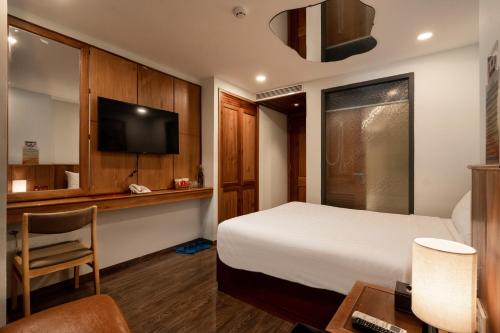 a hotel room with a bed and a tv at Đào Tiên Hotel - Nguyễn Thị Minh Khai in Nha Trang