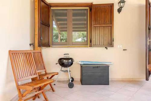 a room with a table and a grill and a chair at Villa Varo by Sicily Travelling Villas in Scopello