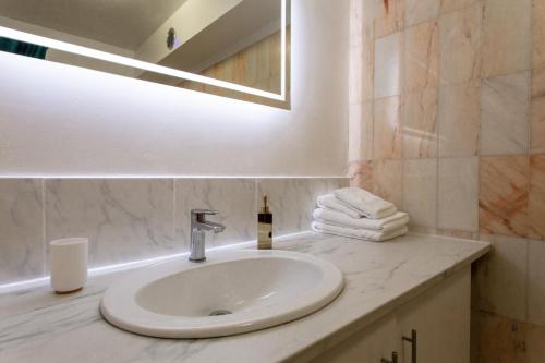 une salle de bain avec un lavabo, un miroir et des serviettes dans l'établissement Studio Terrasse au calme Nice, avec Piscine !, à Nice