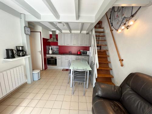 Il comprend un salon et une cuisine avec une table et un canapé. dans l'établissement Belle maison de vacances semi climatisée, clôturée, véranda, 6 couchages, résidence LE VILLAGE DE LA MER LRVM93, à Portiragnes